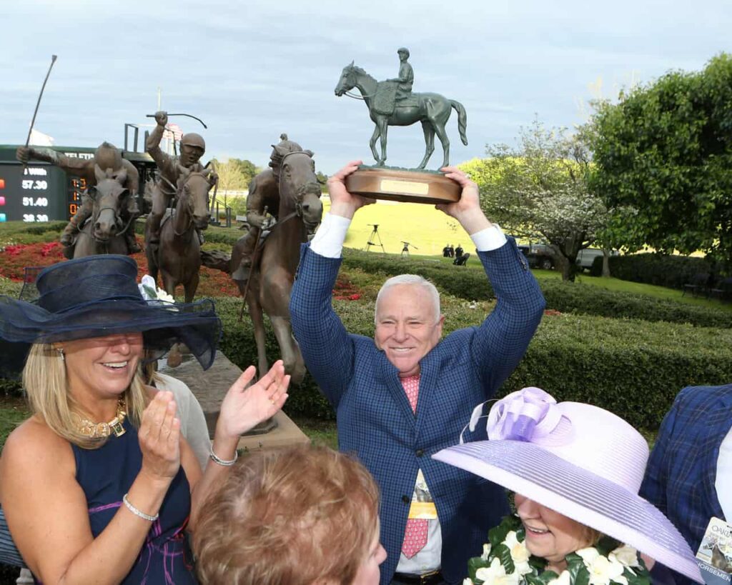 Owner Robert Low holds aloft the trophy for winning the Grade 1 Arkansas Derby